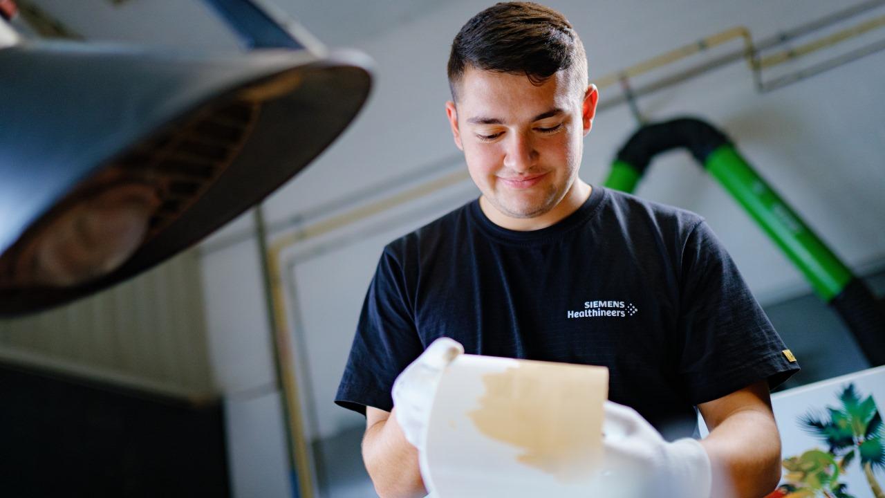 Hannes Schwenk, apprentice at Siemens Healthineers, is working on a component of the MINITOM Kids.