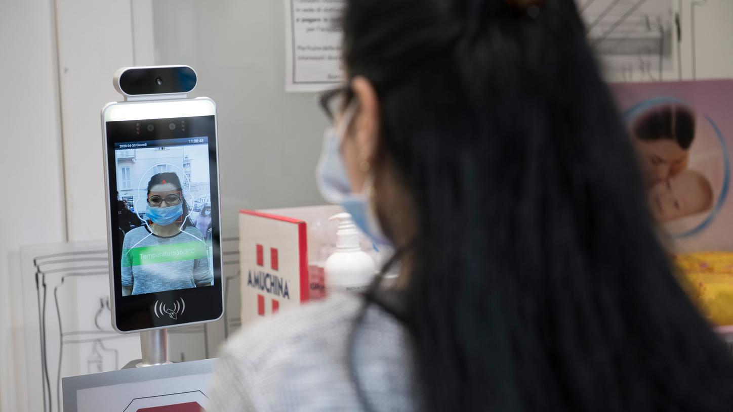 An Italian pharmacy uses a protective robot to take its customers' body temperature. 