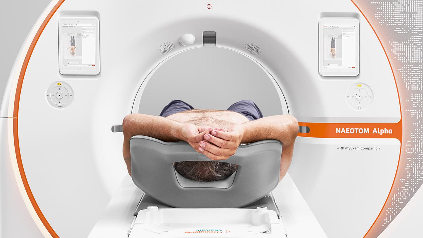 Image of the front of a NAEOTOM Alpha scanner. A patient being placed into the large 82 cm bore has plenty of space.