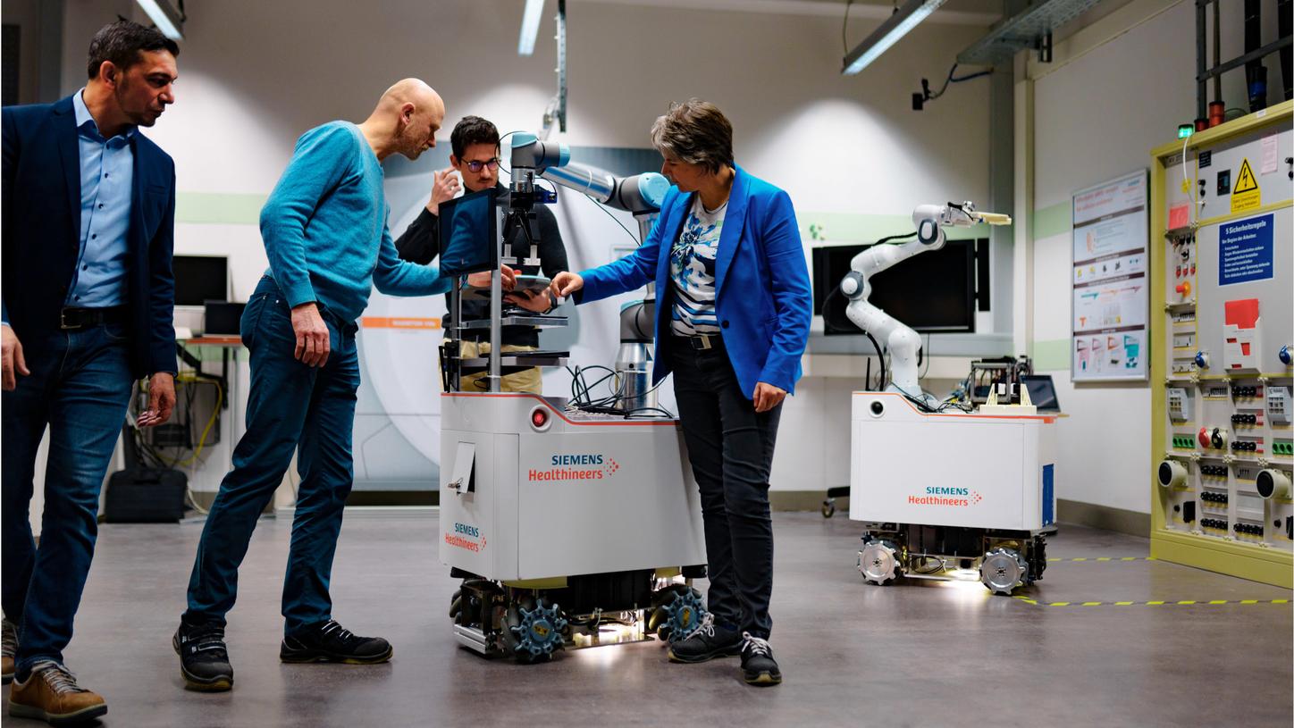 Photo from the innovation lab. Chiheb Dahmani and his team members Claudia Igney, Alexander Horn, and Thomas Mutzke are conducting a test on the Vanessa assistant robot prototype.