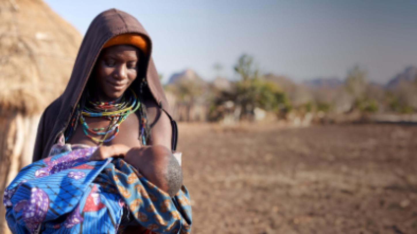 From outreach to outcomes - woman in Angola holding a baby