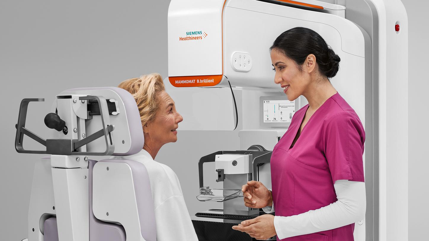The MTA speaks to a patient while the biopsy specimen is being scanned with MAMMOMAT B.brilliant's integrated specimen scanner.